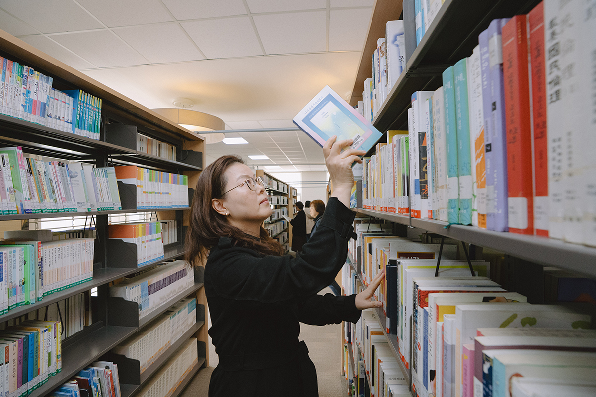 도서관에서 책을 고르고 있는 사진