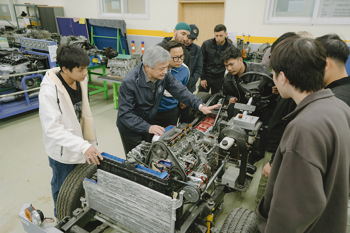 자동차 내부 부품을 보며 교수님의 설명을 듣고 있는 학생들