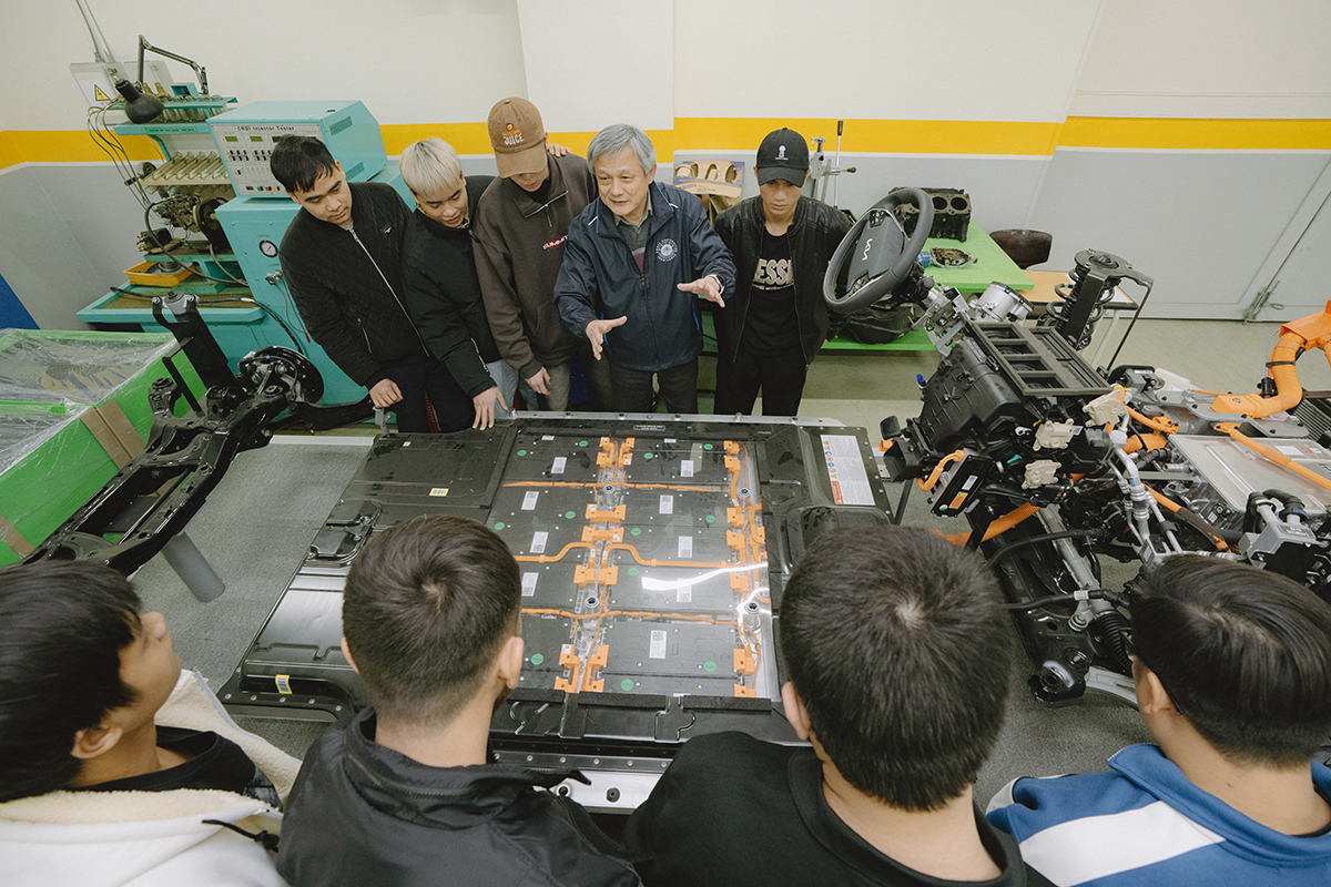 책상의 화면을 보고, 설명을 하는 교수님과 설명을 듣는 학생들