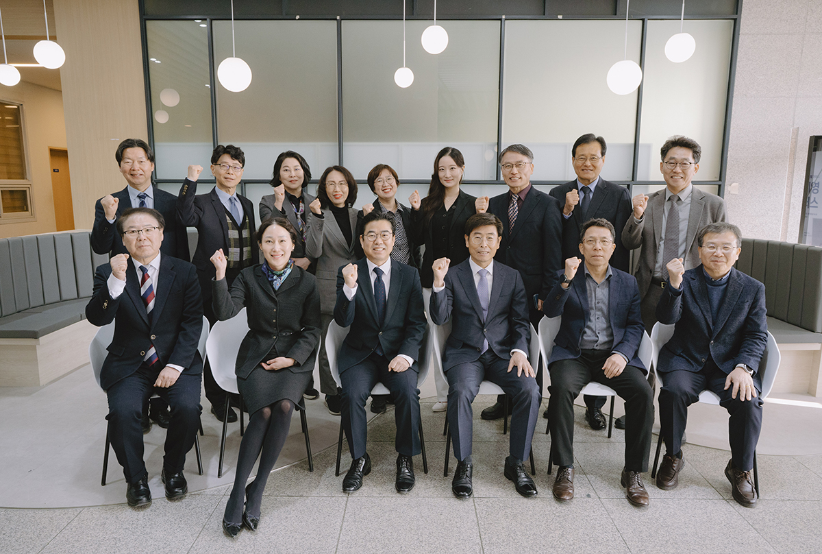 교수님들이 웃으면서 화이팅을 하며 단체사진을 찍고 있는 모습