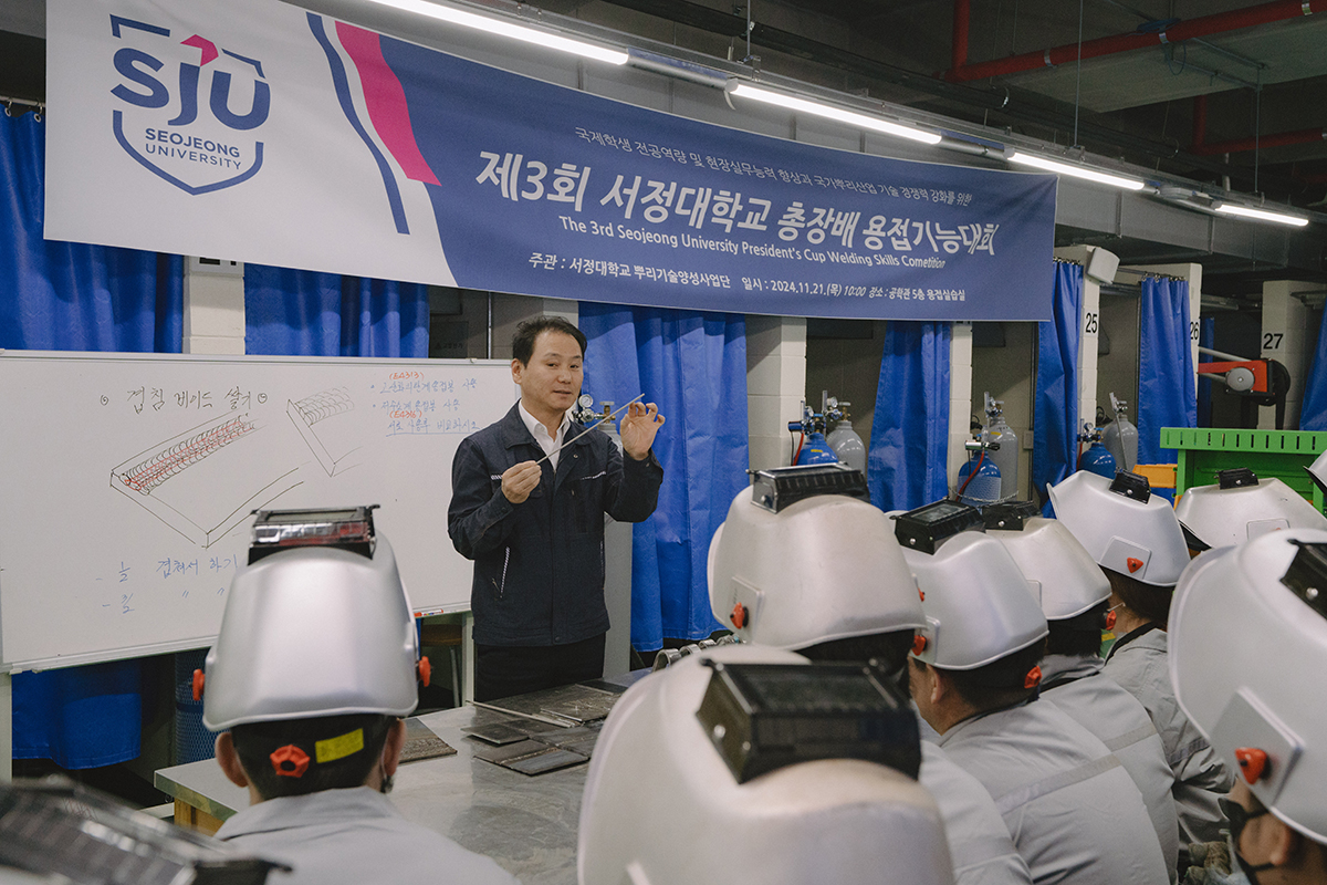 용접실습전 교수님의 이야기를 듣고있는 학생들 사진 