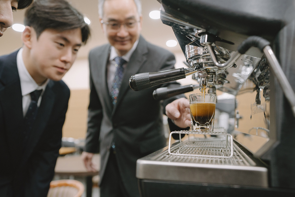 머신에서 커피 추출하는 방법을 교육받고 있는 사진