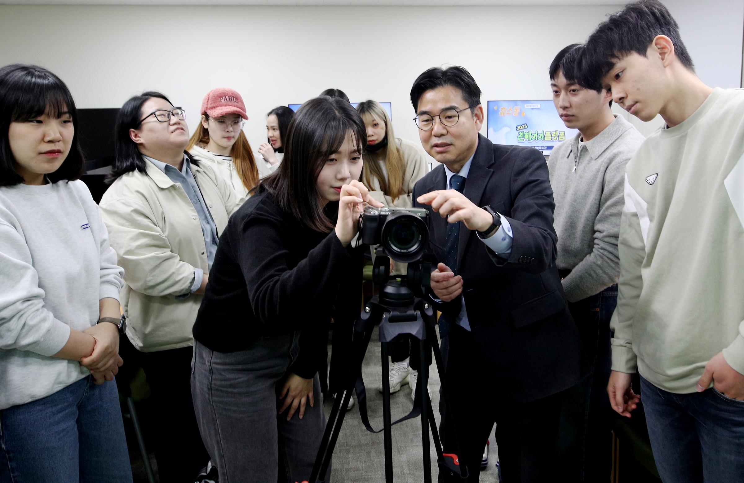 설치형 카메라 조작법을 설명하는 교수님과 집중하는 학생들